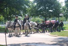 U.S. Army Caisson Platoon escort a coffin at Arlington National Cemetery.