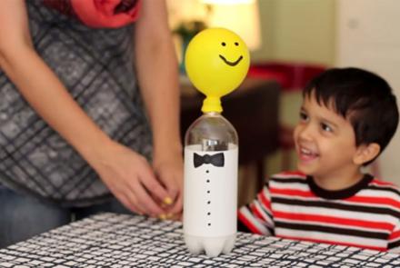 A young boy makes carries out a balloon science experiment.